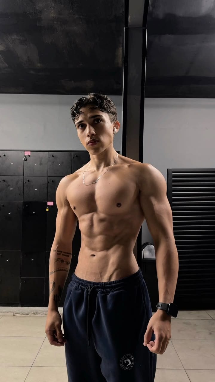 Jota de frente, sem camisa, mostrando o abdômen definido